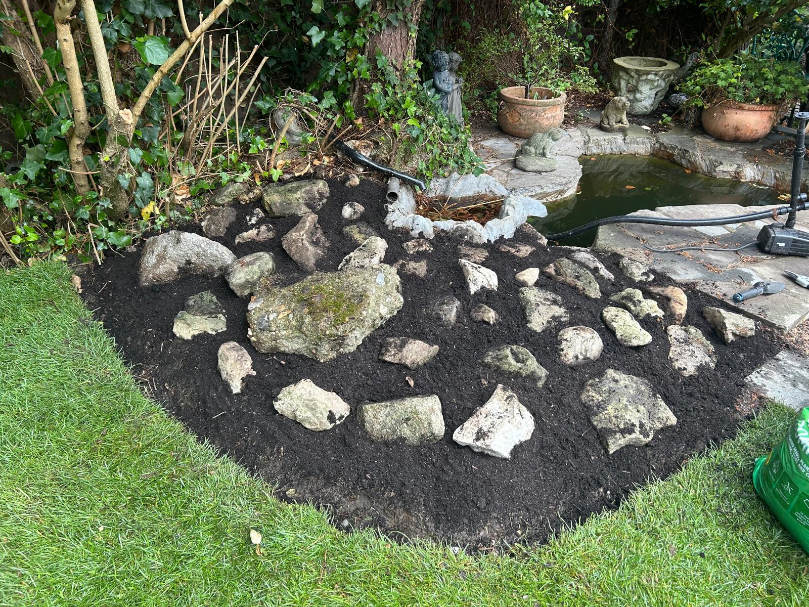 Rockery build in progress beside pond