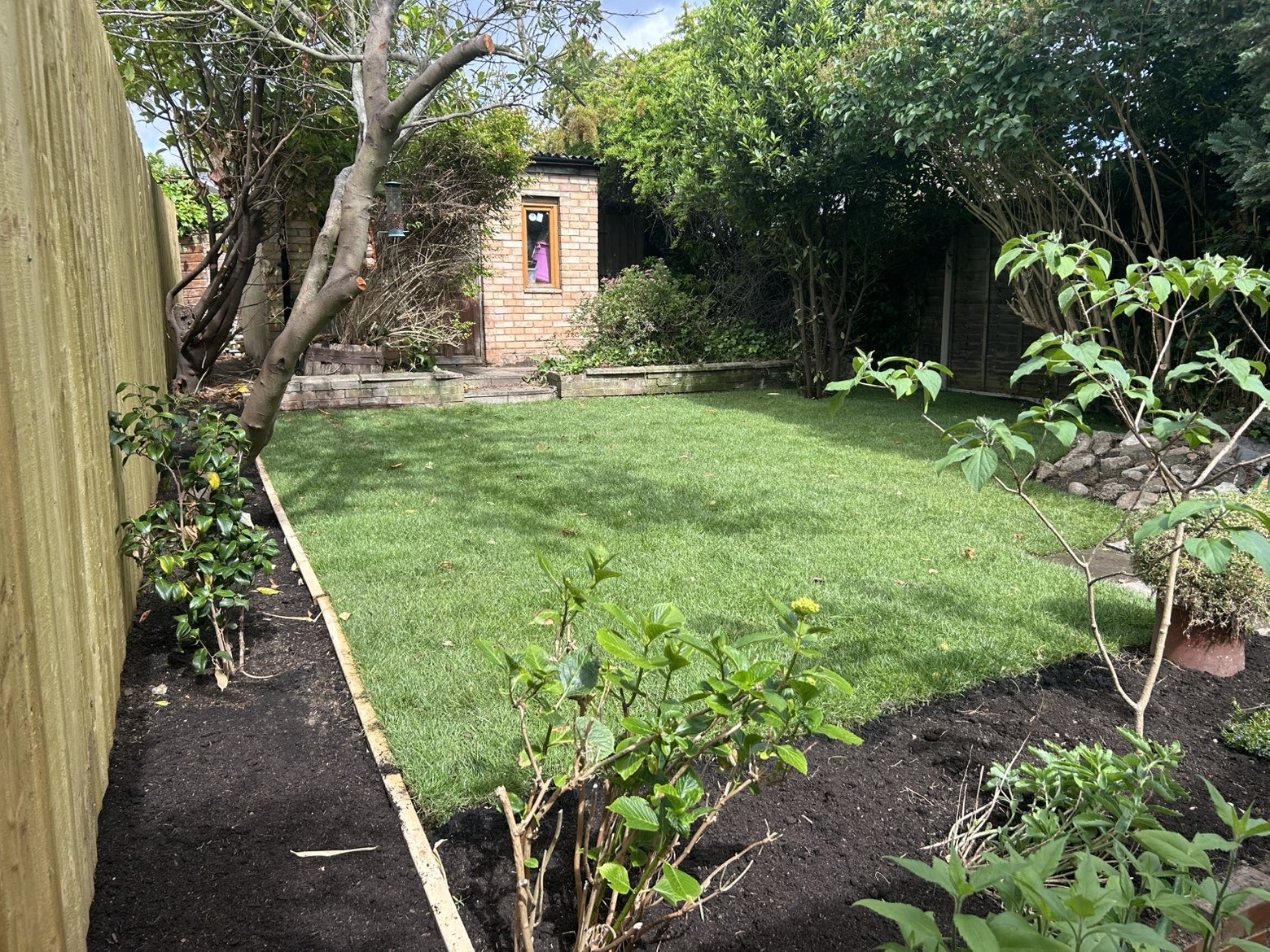 Same garden with a freshly laid green lawn
